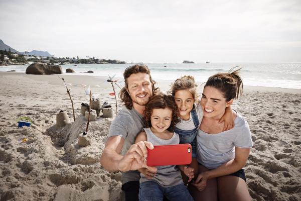 Imagen de una familia haciéndose una foto en la playa