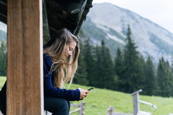 Chica en las montañas usando móvil