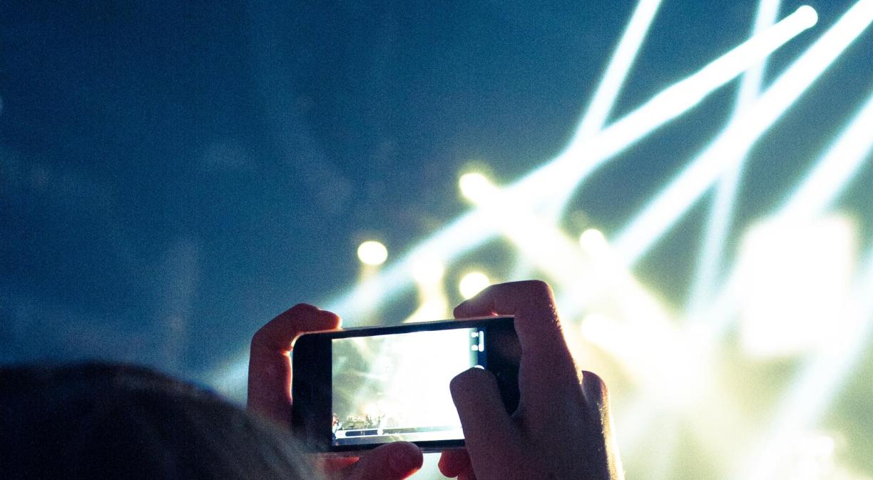 Mujer haciendo foto con un móvil en un concierto