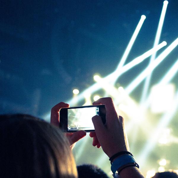 Mujer haciendo foto con un móvil en un concierto