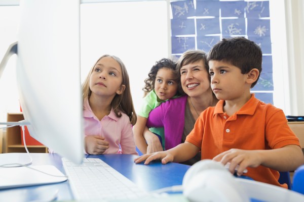 Porfesora y alumnos mirando la pantalla del ordenador
