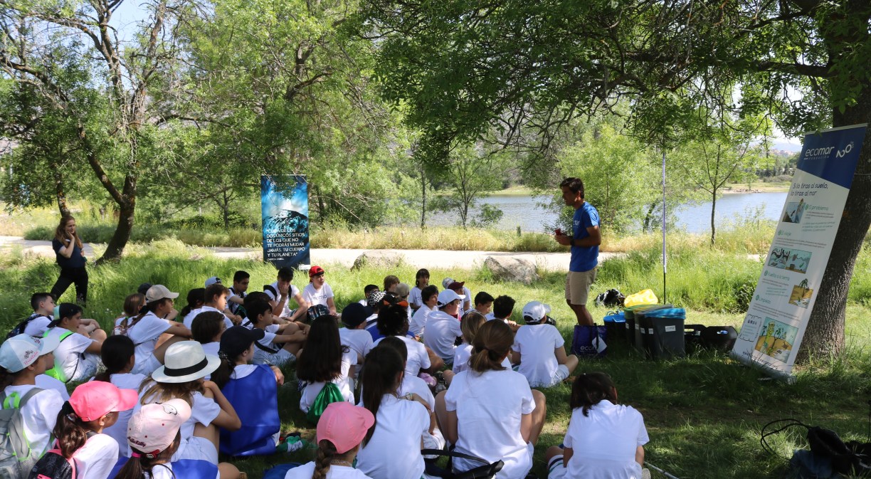 Imagen de un grupo de niños en el campo con un profesor enfrente