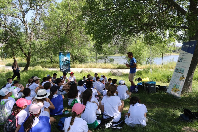 Imagen de un grupo de niños en el campo con un profesor enfrente