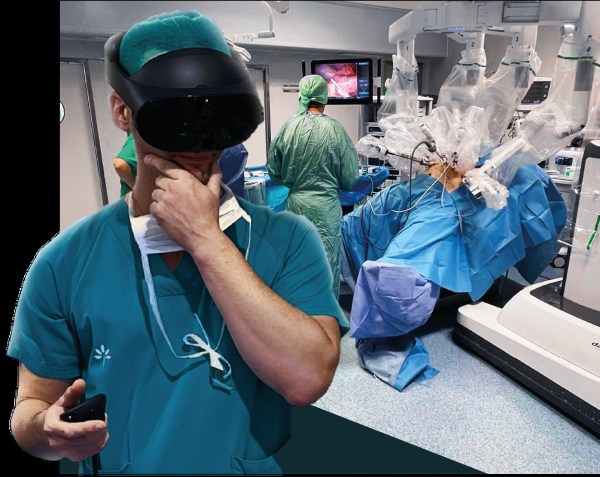 Imagen del robot da Vinci y una mesa de operaciones. En primer plano una persona con gafas de realidad virtual