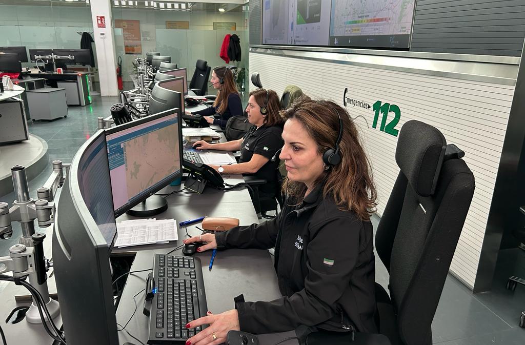 Dos trabajadoras del 112 con una ordenador y unos cascos atendiendo llamadas sentadas