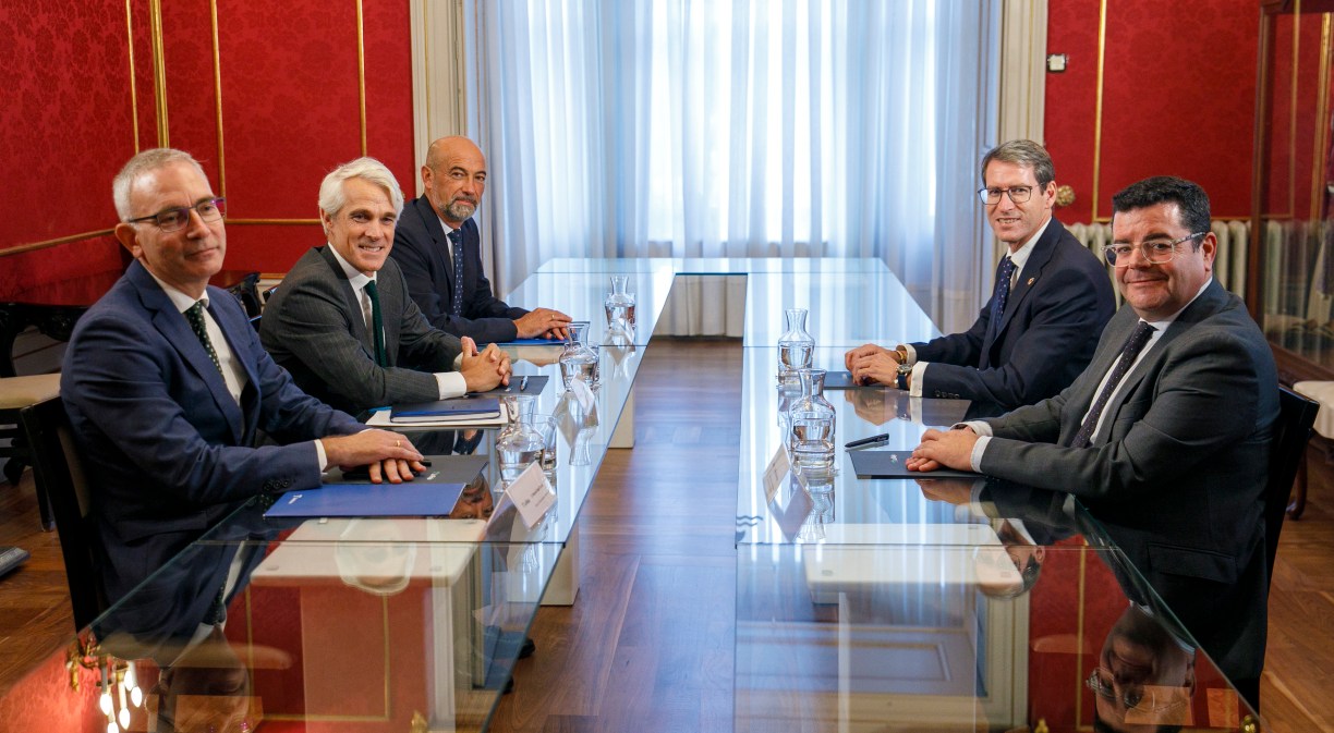 Seis personas alrededor de una mesa mirando a la cámara