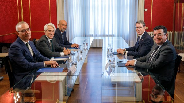 Seis personas alrededor de una mesa mirando a la cámara