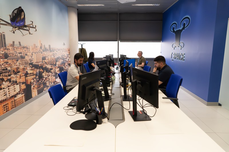 Imagen de una sala con varios pilotos alrededor de una mesa trabajando delante de un ordenador